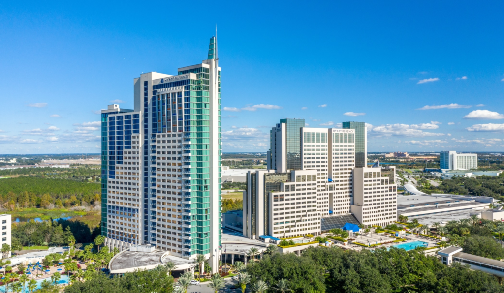 Aerial view of the Hyatt Regency Orlando resort towers under a blue sky in Orlando, Florida.